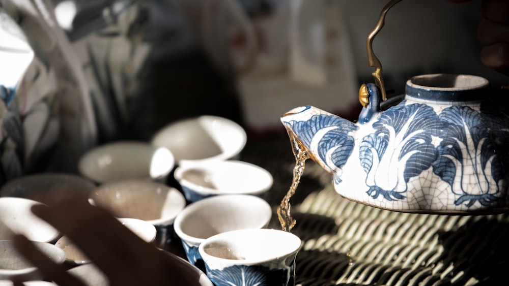 white and blue ceramic teacup on brown woven table mat