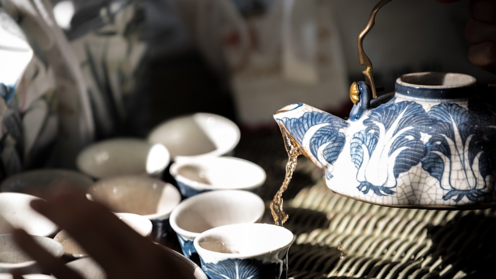xícara de chá de cerâmica branca e azul no tapete de mesa tecido marrom