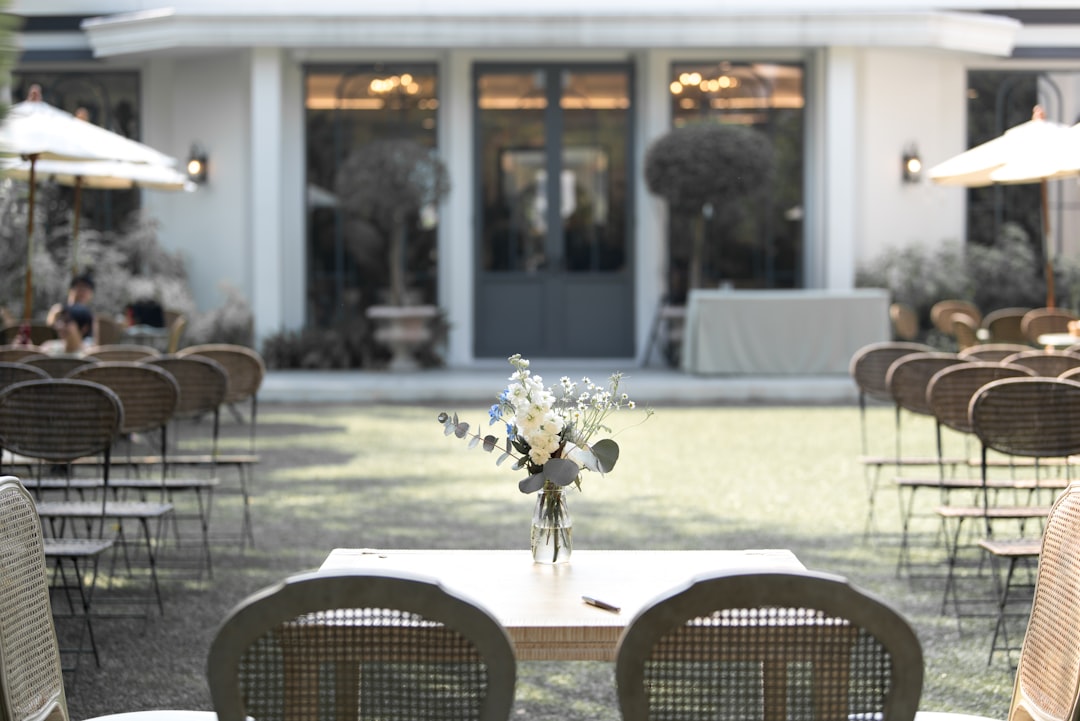 White and Green flowers were in the vase and put on the wooden table for outdoor garden decoration.