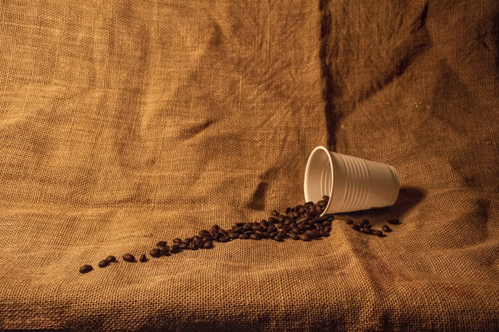 white plastic cup on brown textile