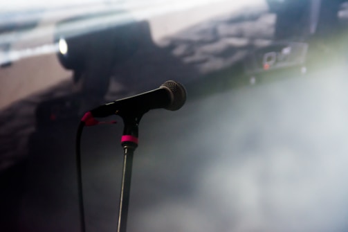 A microphone and music equipment set up in a dimly lit studio.