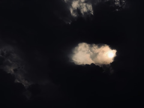 A dramatic sky with dark clouds parting to reveal a bright light