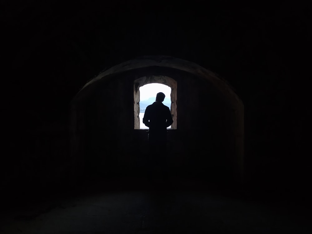 トンネルに立つ黒いジャケットの男
