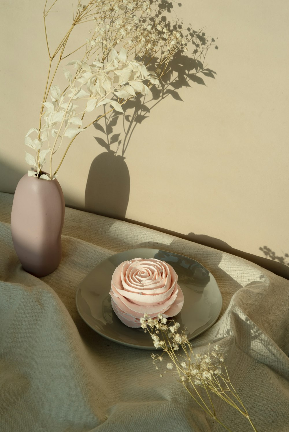 pink rose in brown ceramic vase on brown wooden table