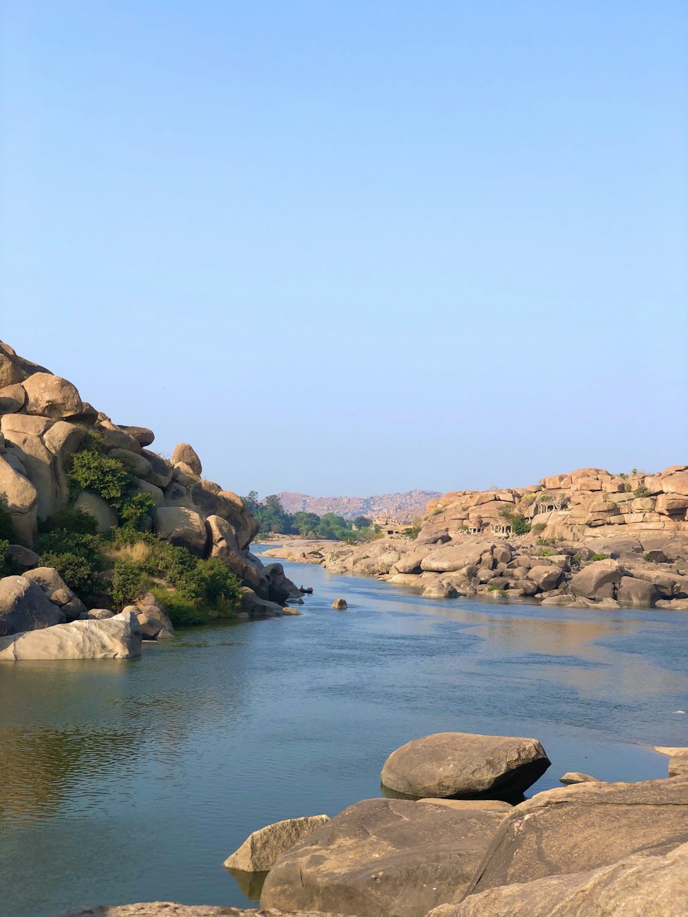 brown rocky mountain beside blue sea under blue sky during daytime