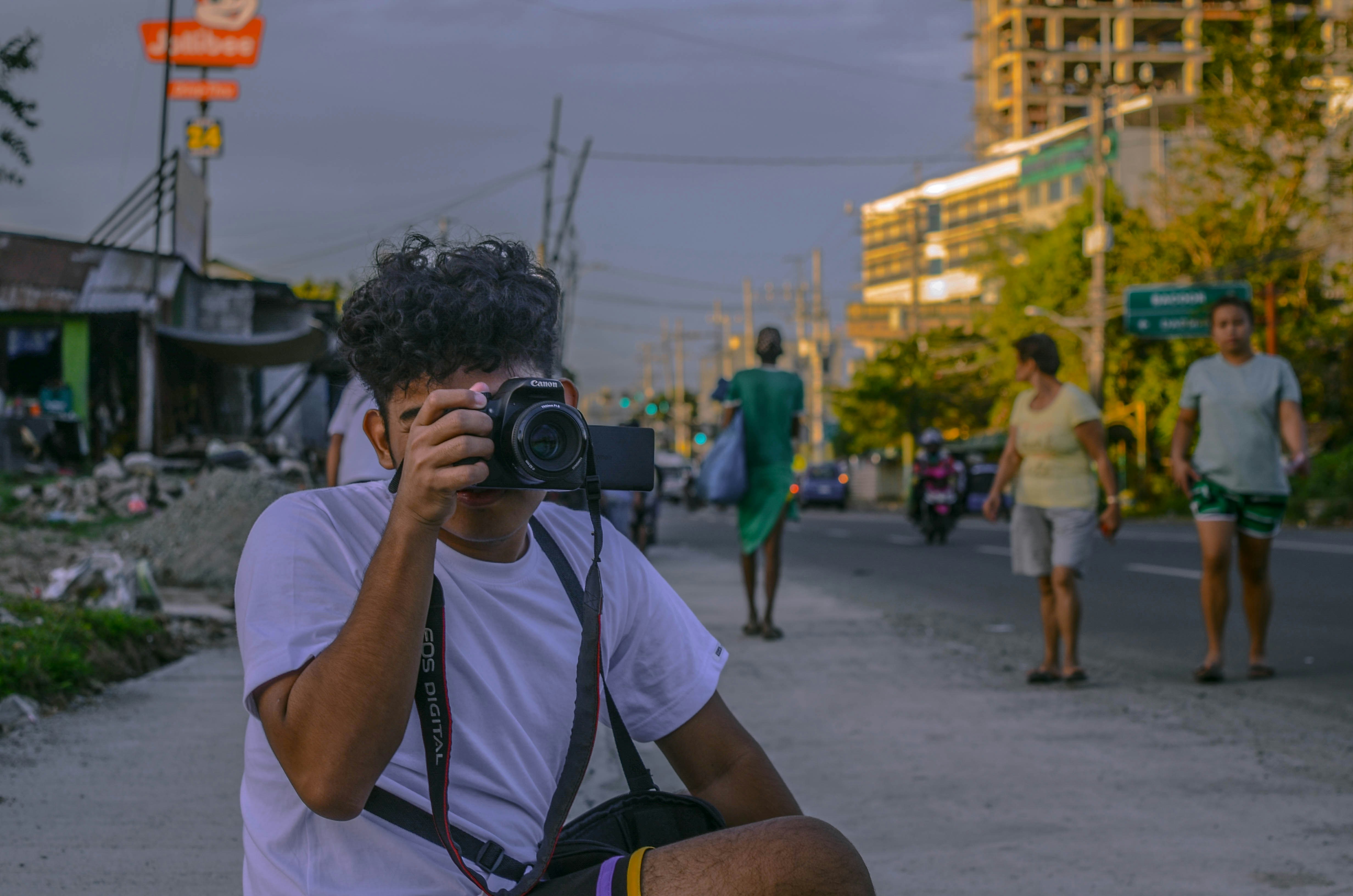 man in white t-shirt holding black camera