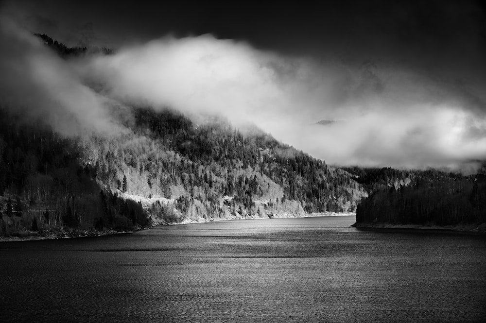 grayscale photo of mountain near body of water