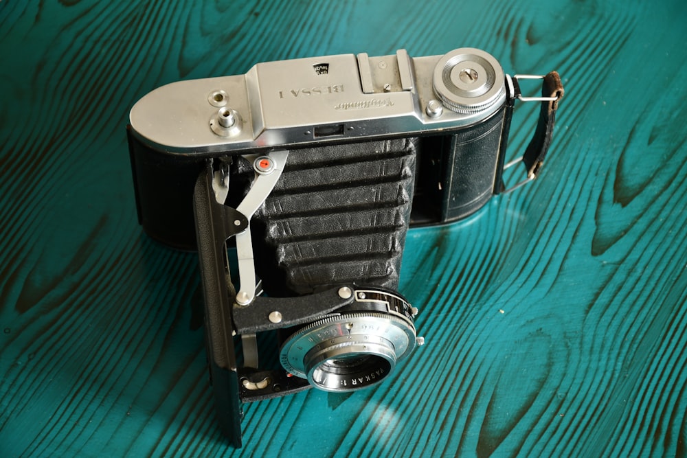black and silver camera on green textile