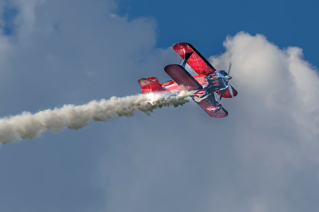 red and white jet plane in mid air