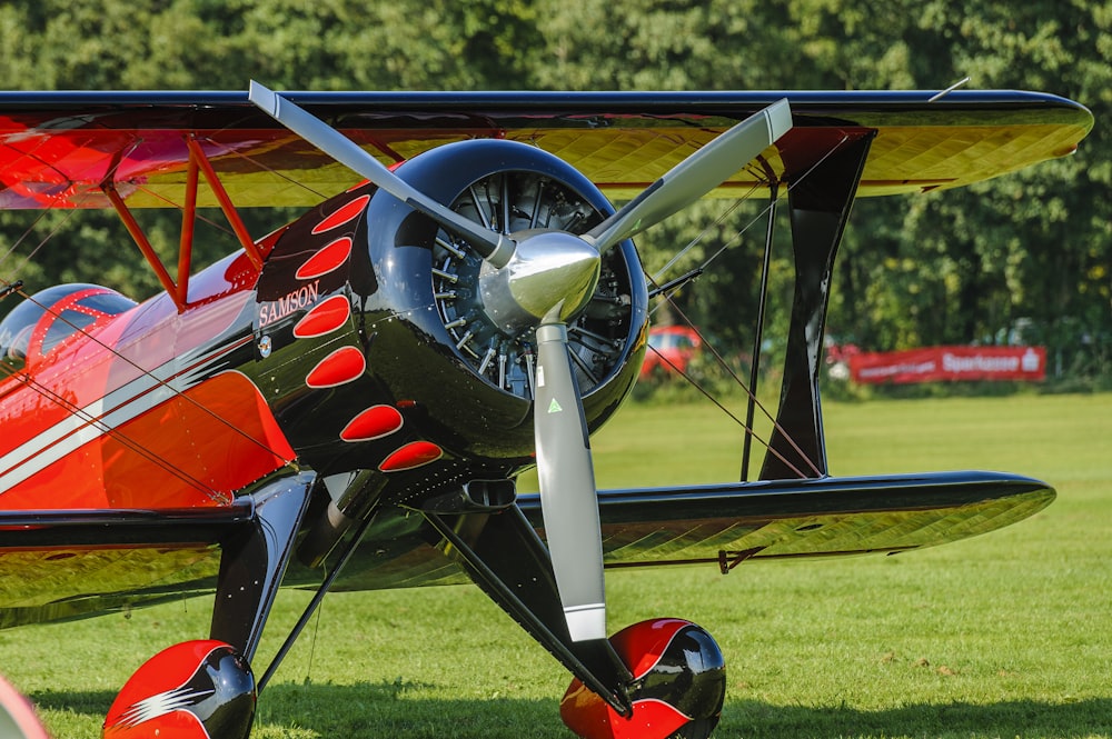 blue and red airplane on green grass field during daytime