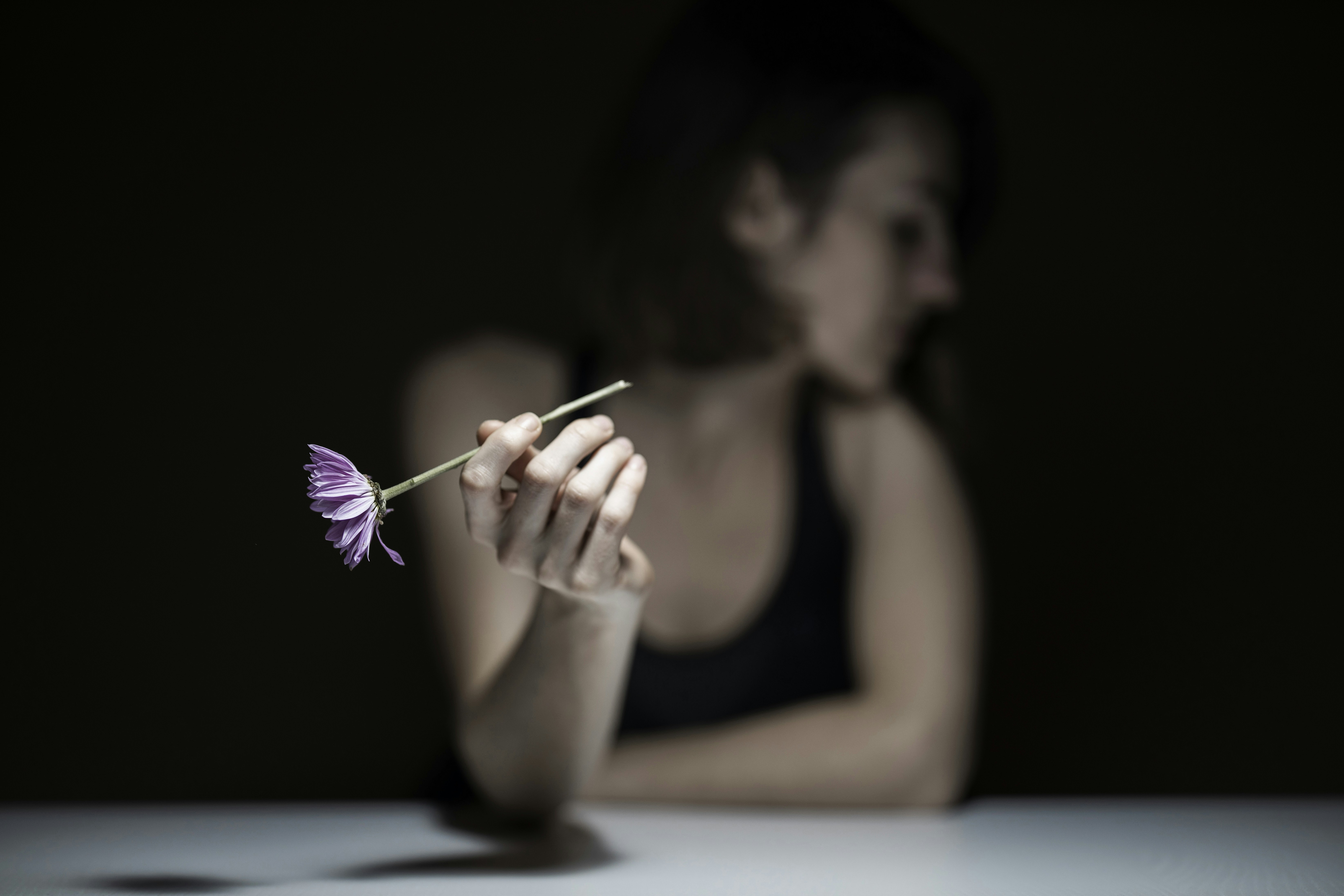 woman in black tank top holding purple paint brush