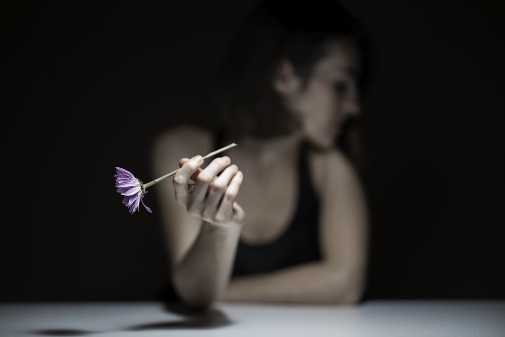 woman in black tank top holding purple paint brush