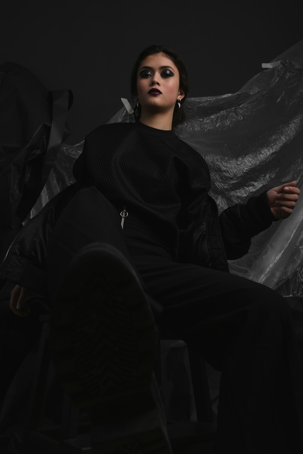 a woman sitting in a chair with a black background