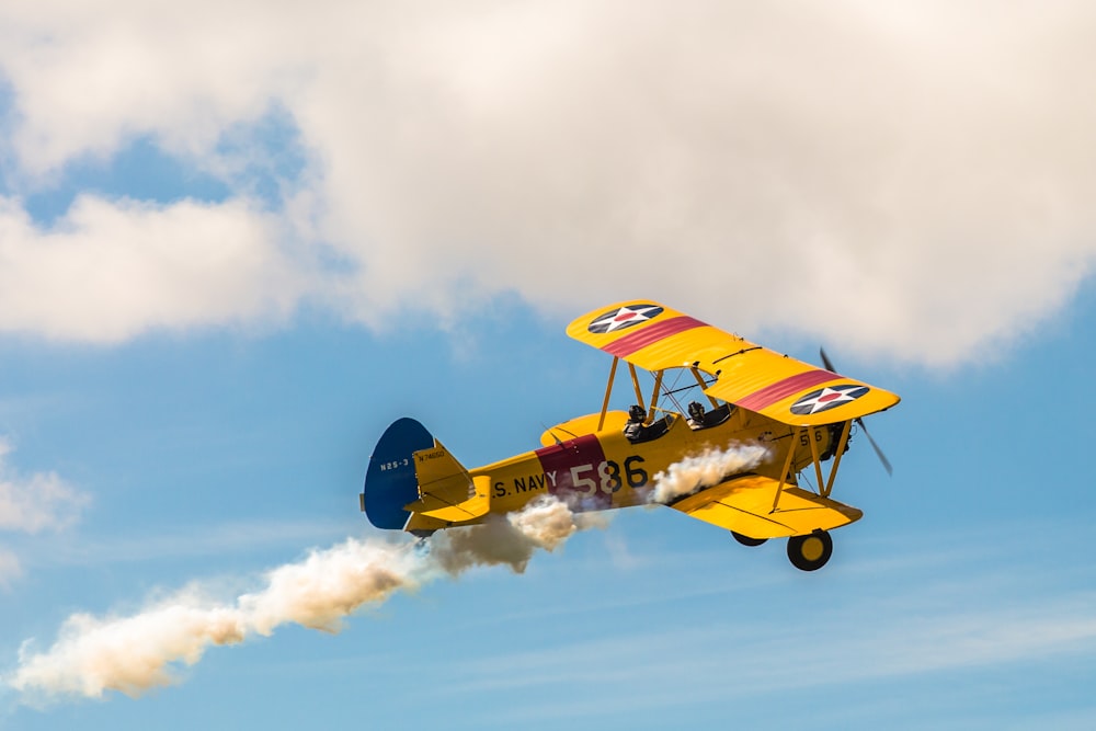 yellow and black plane flying in the sky