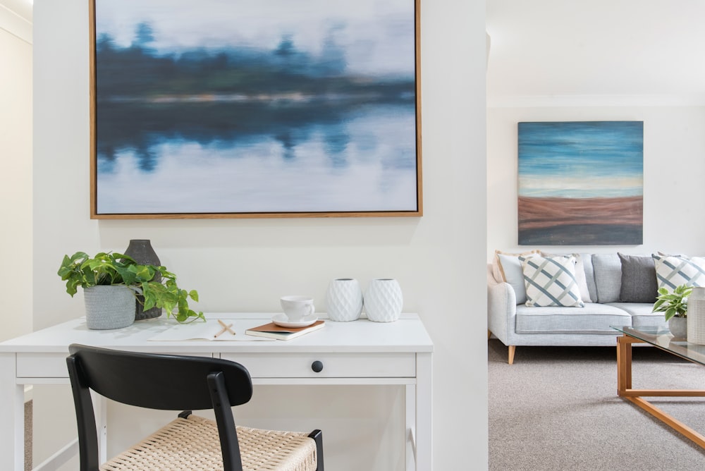 white and black table with chairs near body of water painting