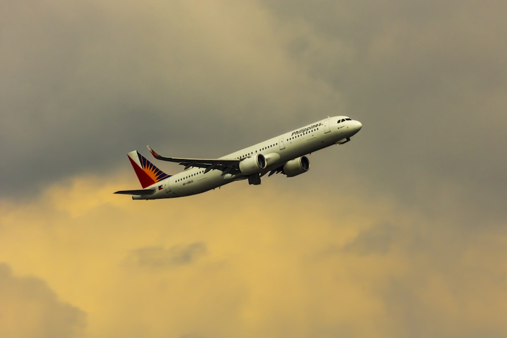 aereo bianco e rosso che vola nel cielo durante il giorno