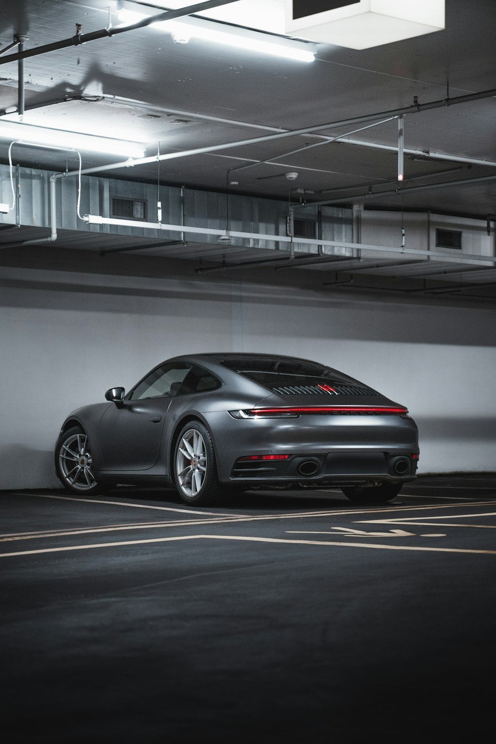 Porsche 911 argentée garée dans un parking