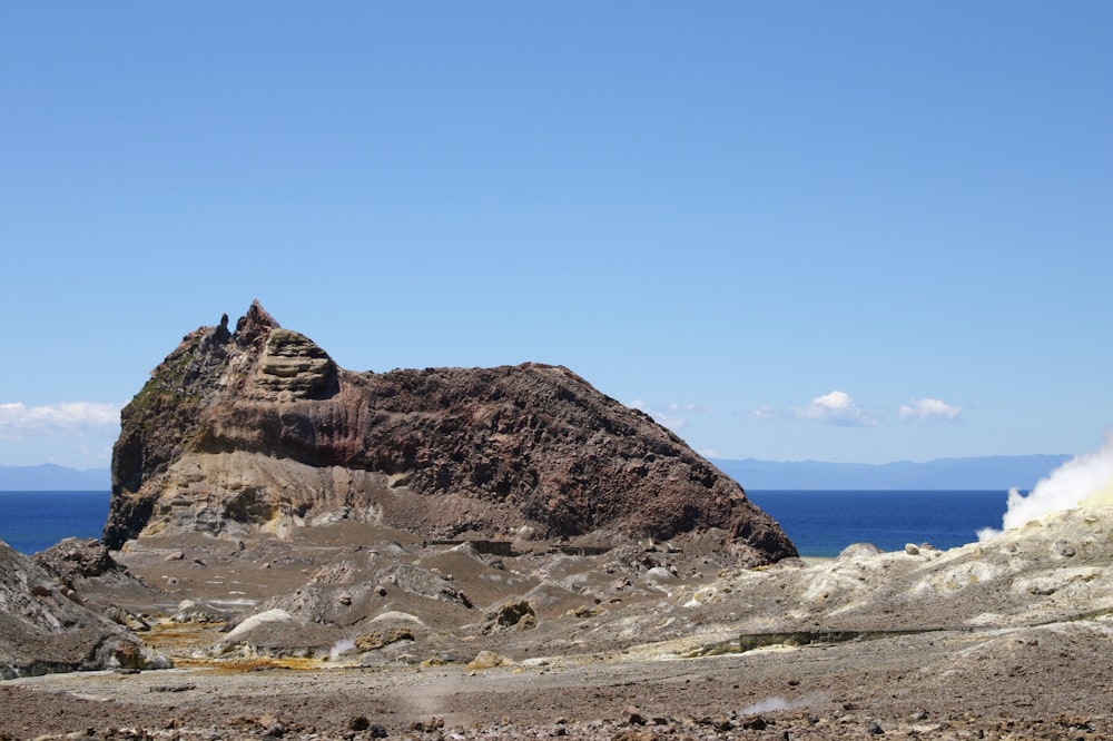 Formazione rocciosa marrone sulla riva del mare durante il giorno