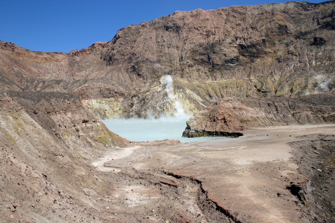 water falls on brown rocky mountain under blue sky during daytime