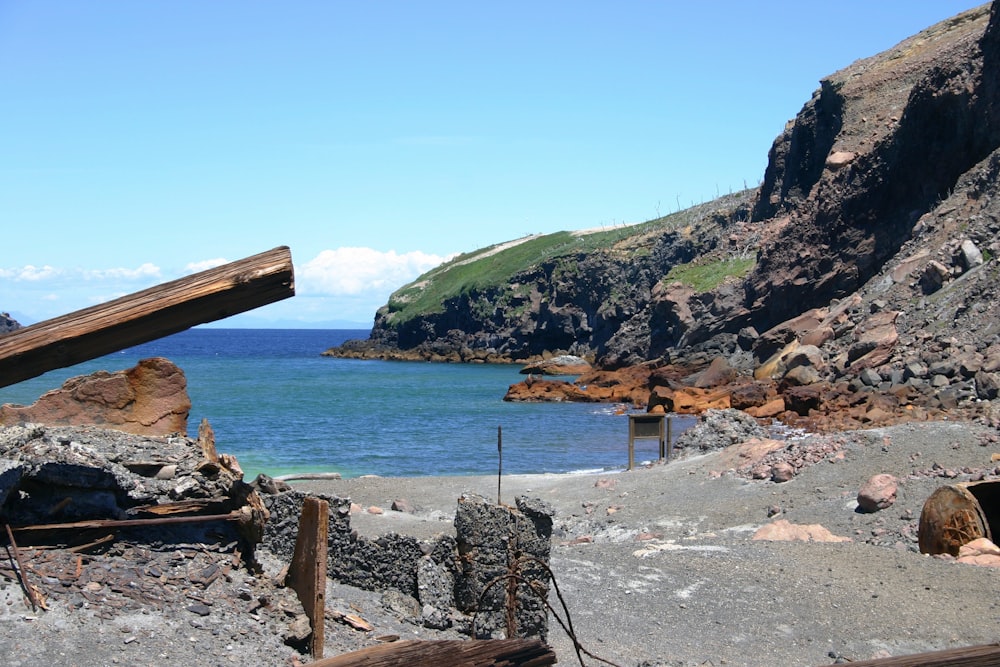 suporte de madeira marrom na costa rochosa cinzenta durante o dia