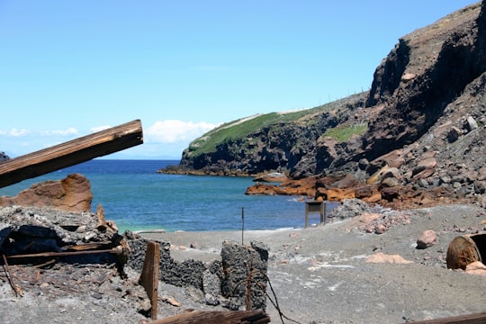 brown wooden stand on gray rocky shore during daytime in Whakaari / White Island New Zealand