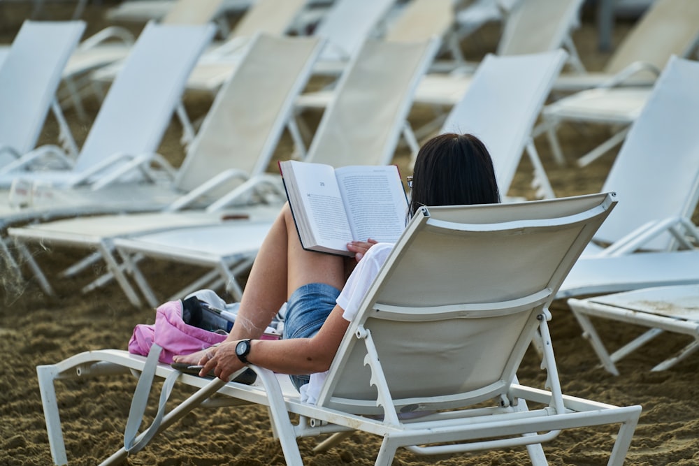 woman in blue denim shorts sitting on white folding chair