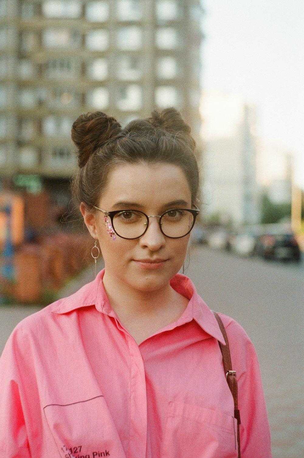 Mujer con camisa abotonada rosa con anteojos