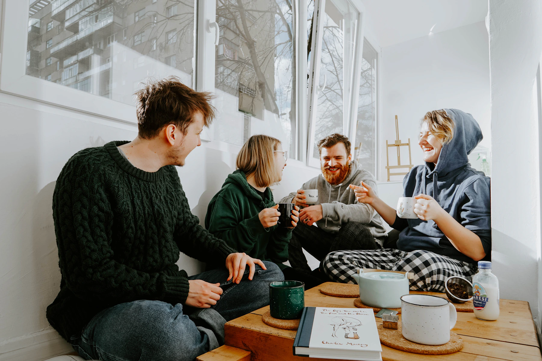 Friends gathered around a table with warm drinks.