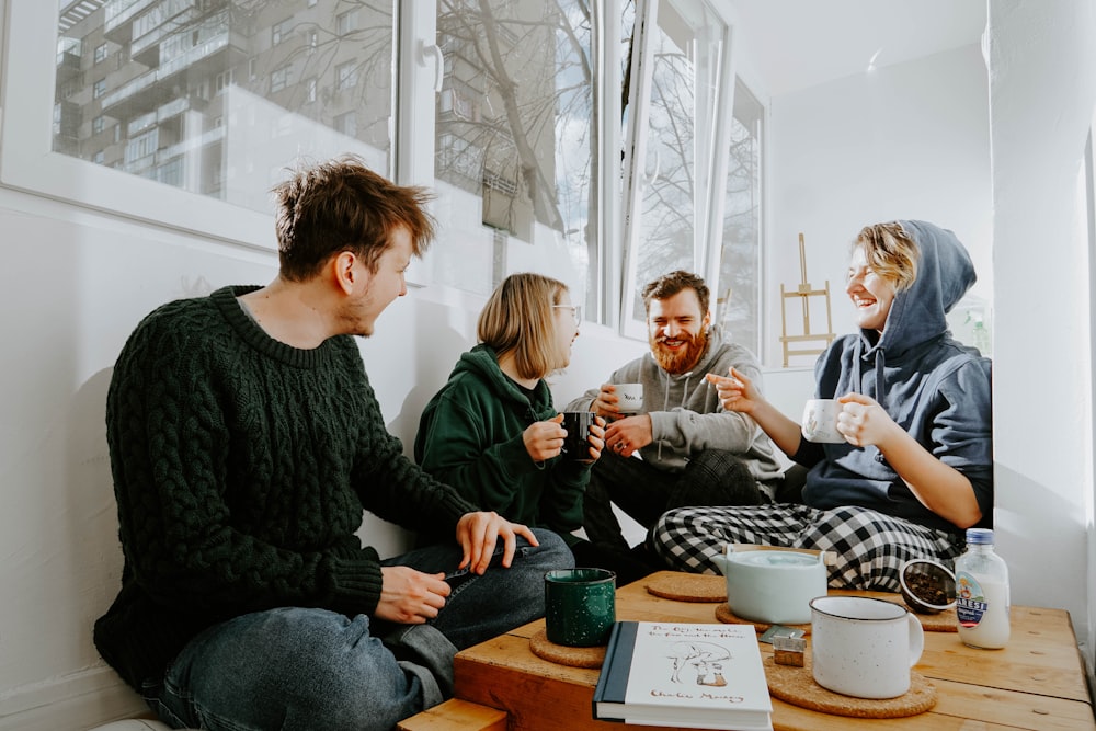 3 women and 2 men sitting on brown wooden table