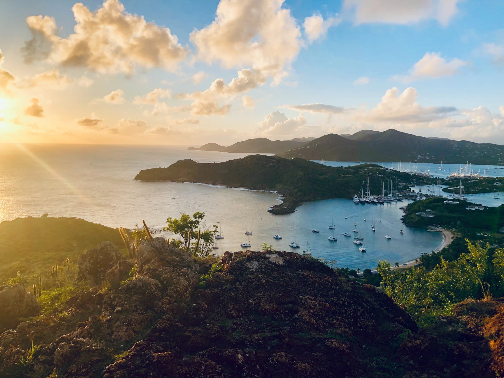 Sheltered bays and sailing boats seen across Antigua at sunset