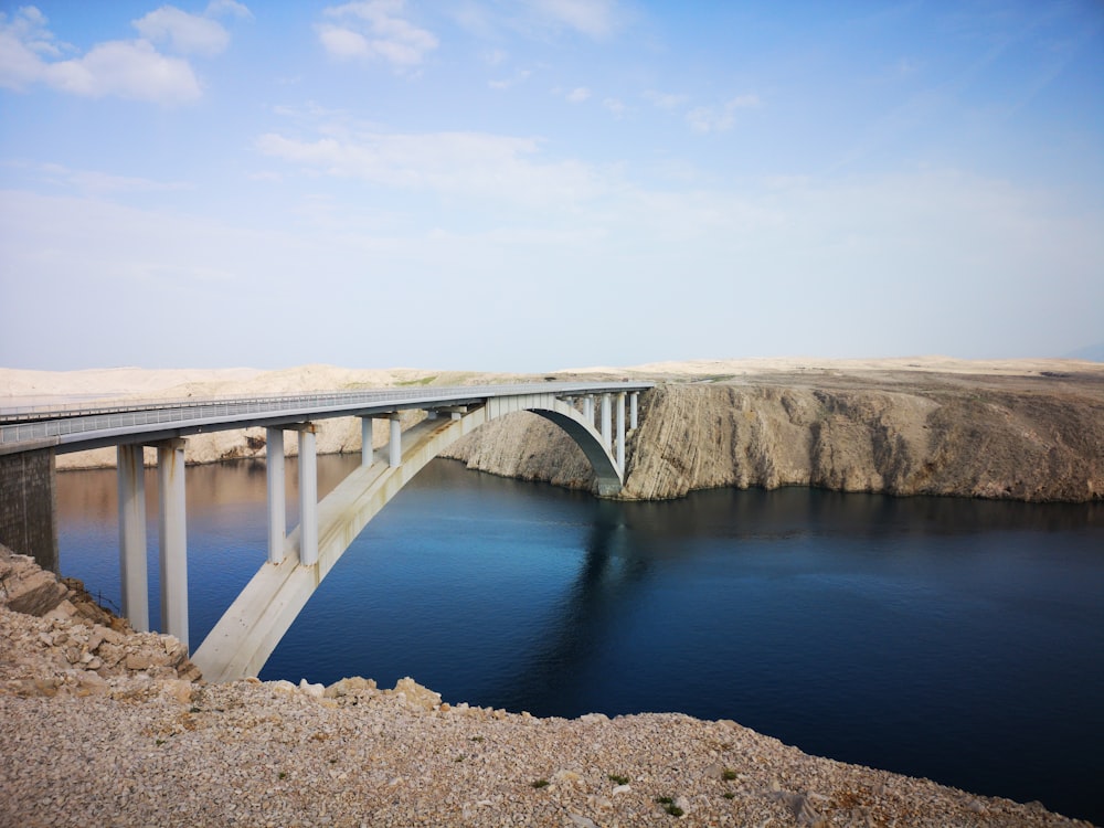 gray concrete bridge over blue sea under blue sky during daytime