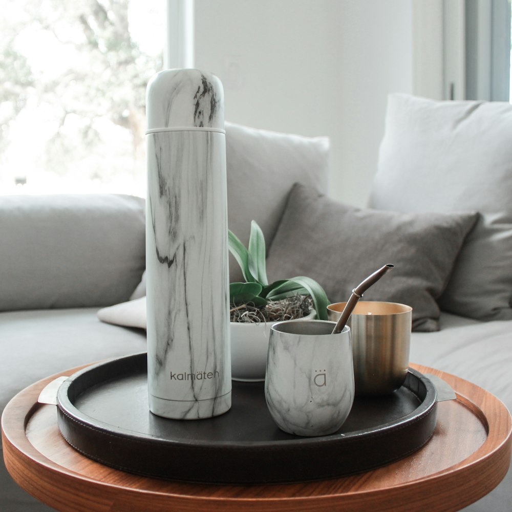 white ceramic mug on brown wooden round table