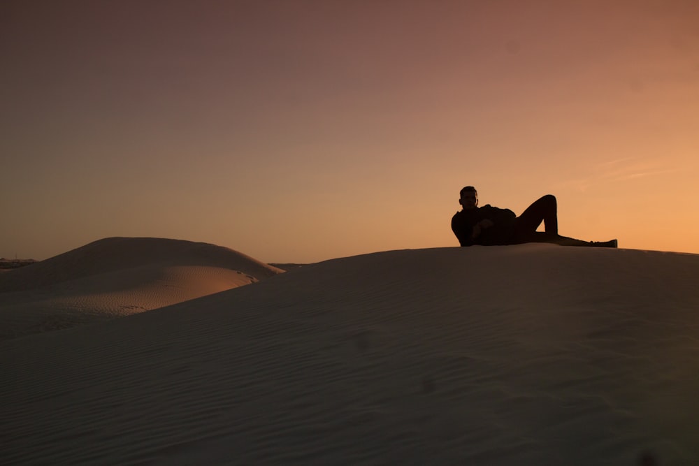 Mann sitzt tagsüber auf Sand