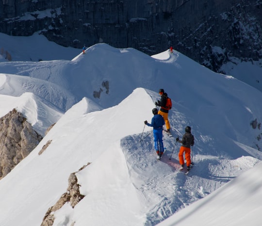 man in orange jacket and black pants on snow covered mountain during daytime in Bovec Slovenia