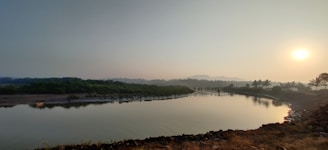 A serene sunrise over the Nile River, with soft golden light reflecting on calm waters and palm trees lining the shore.