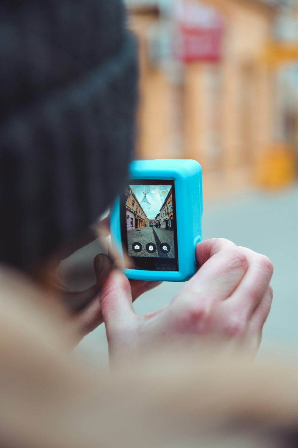 person holding orange and black digital device