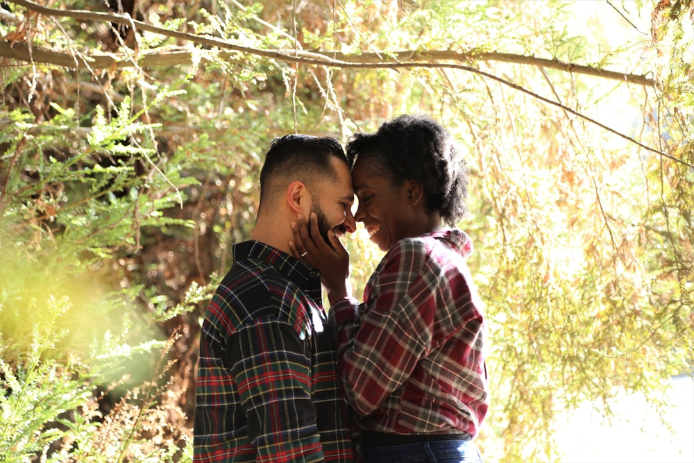 man in blue white and red plaid dress shirt kissing woman in white shirt