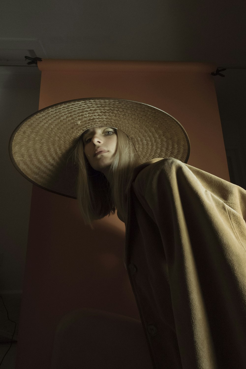 woman in brown coat wearing brown sun hat