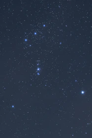 An ancient astrologer’s hand tracing star patterns in the night sky.