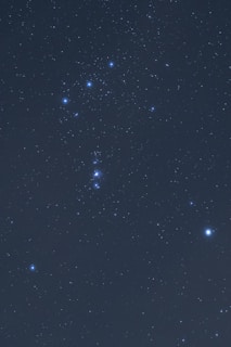 A clear view of the night sky displaying numerous stars, with a prominent constellation visible, featuring a distinctive pattern of bright stars.