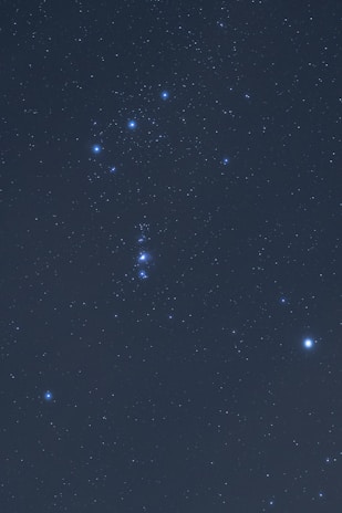 A clear view of the night sky displaying numerous stars, with a prominent constellation visible, featuring a distinctive pattern of bright stars.
