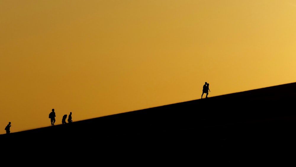 silhueta de 2 pessoas em pé no topo do edifício durante o pôr do sol