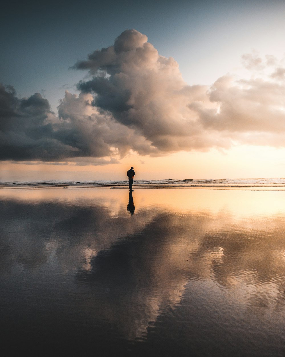 person standing on body of water during sunset