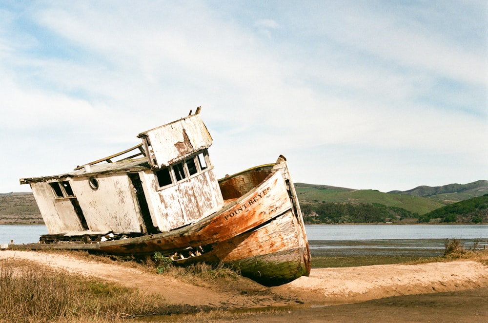 brown and white boat on seashore during daytime