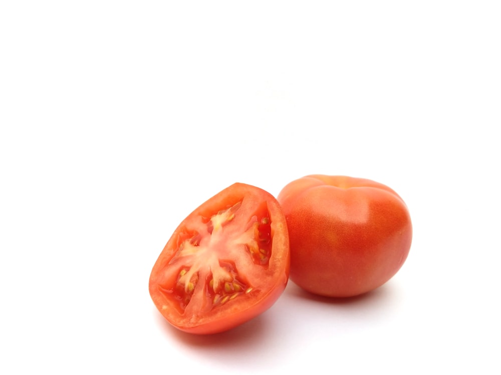 2 red round fruits on white surface