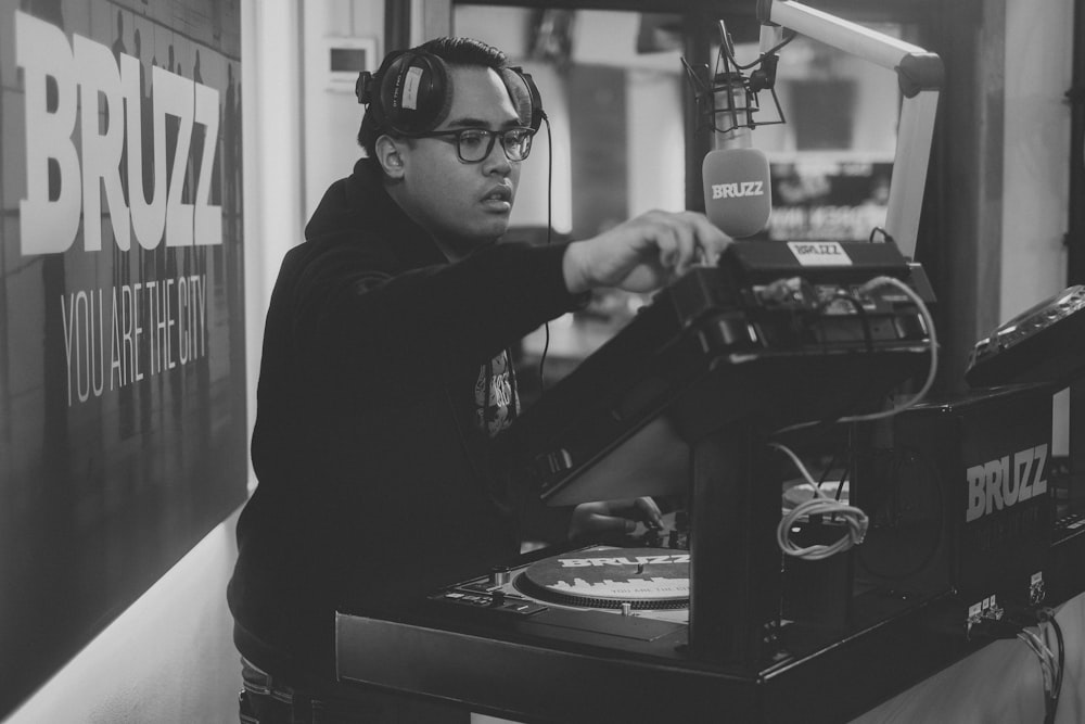 Hombre con camisa negra de manga larga jugando al controlador de DJ