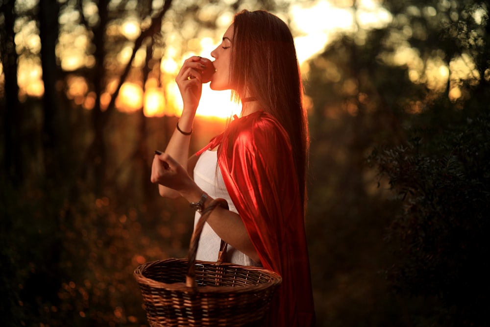 woman in red dress holding brown woven basket