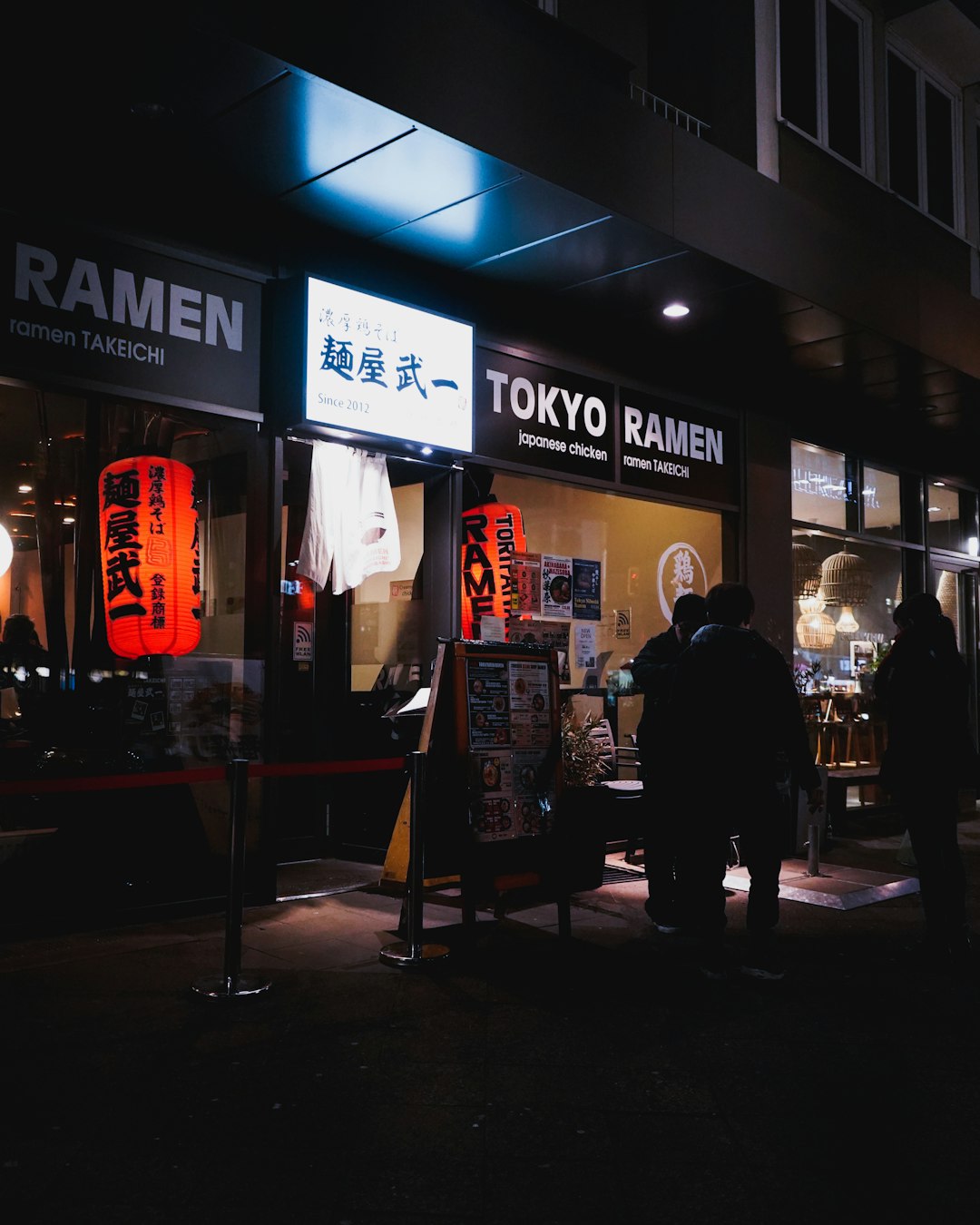 people walking on sidewalk during night time