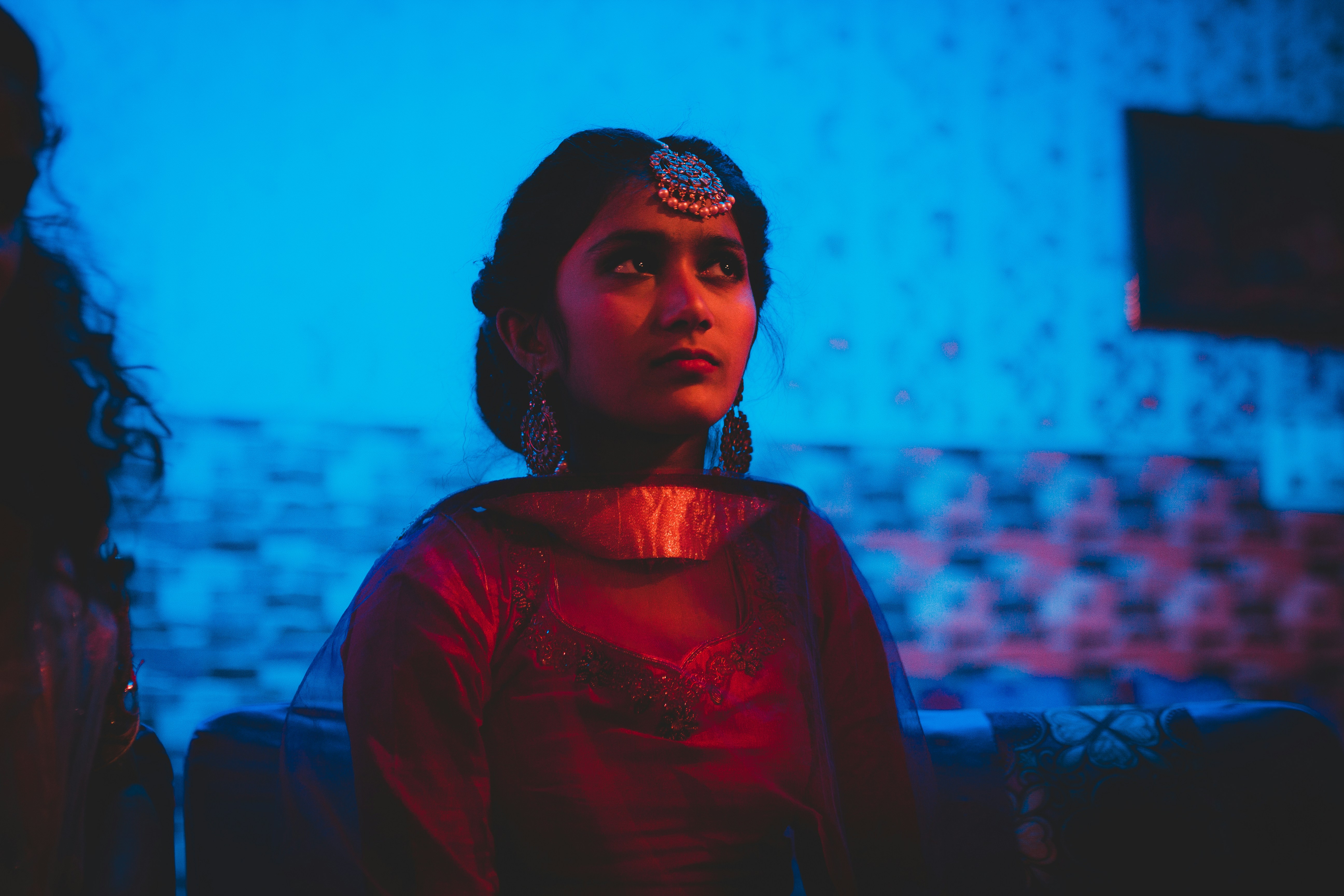 Femme en chemise rouge à manches longues portant une coiffe florale blanche et noire