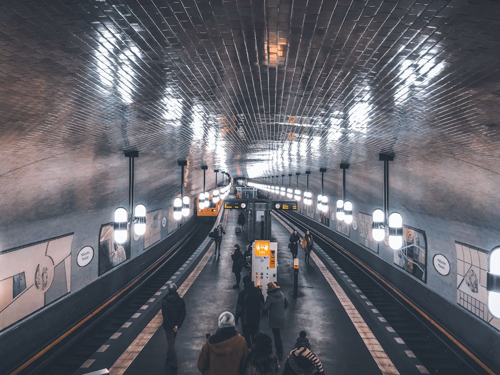 a group of people walking through a train station